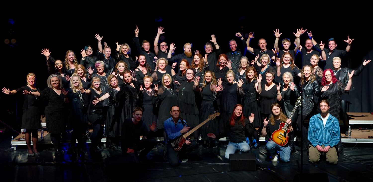Yhteiskuva lavalla Varkauden Laulu -kuorosta ja bäändistä.