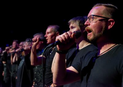 Kuoron bassot laulamassa mikrofoneihin.