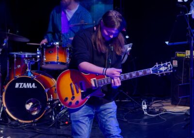 Kitaristi esiintymässä sinisissä valoissa.