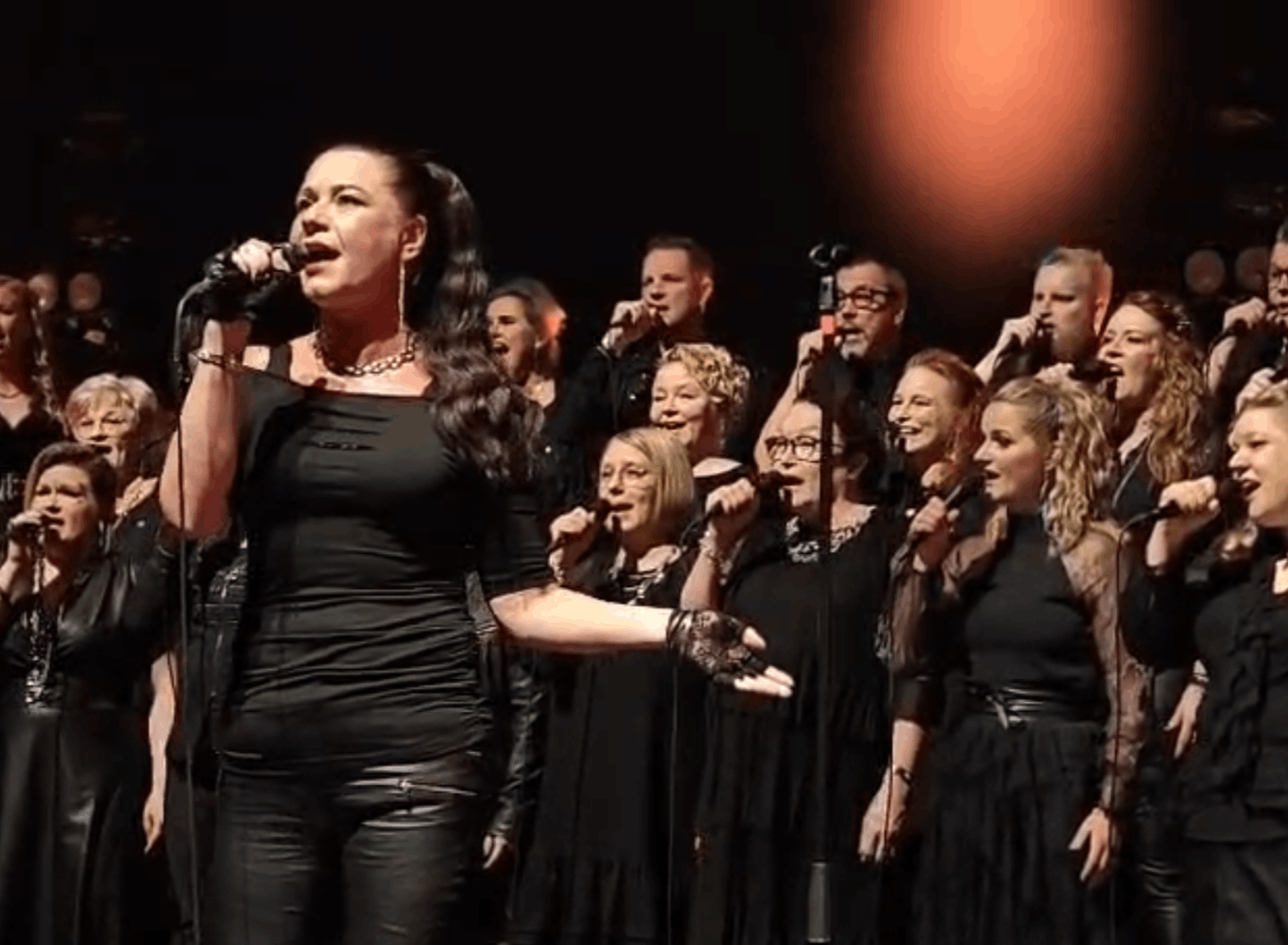 5824d9b1-56bb-41ec-9a1c-64ab7e88c58b (1) Solisti Mirva Janhunen ja kuoro esiintymässä lavalla.